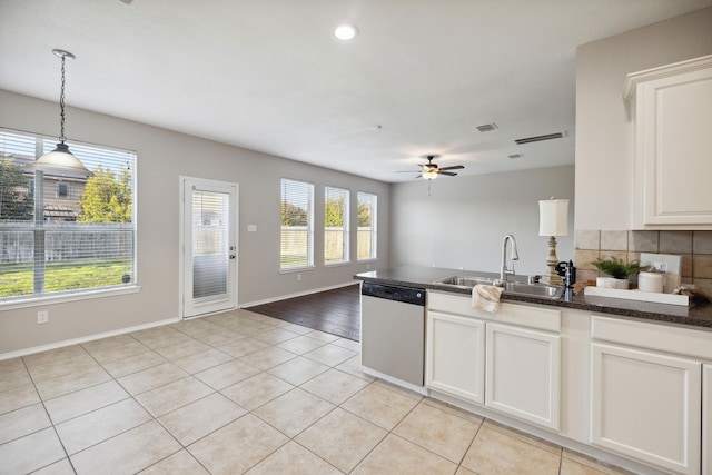 kitchen featuring white cabinets, sink, hanging light fixtures, stainless steel dishwasher, and light tile patterned floors