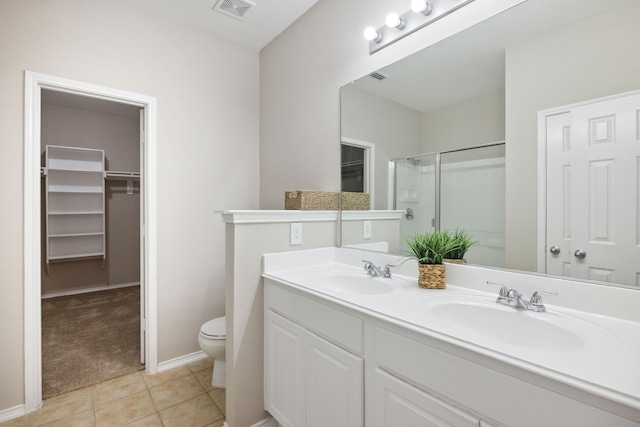 bathroom with tile patterned flooring, vanity, toilet, and walk in shower