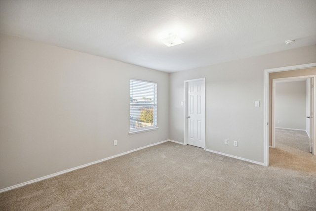 unfurnished bedroom featuring light carpet, a closet, and a textured ceiling