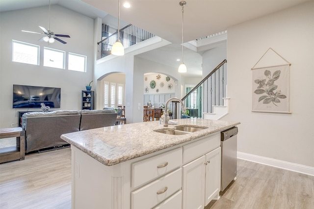 kitchen with ceiling fan, an island with sink, hanging light fixtures, high vaulted ceiling, and dishwasher