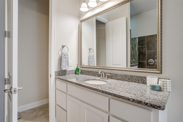 bathroom with walk in shower, vanity, and tile patterned flooring