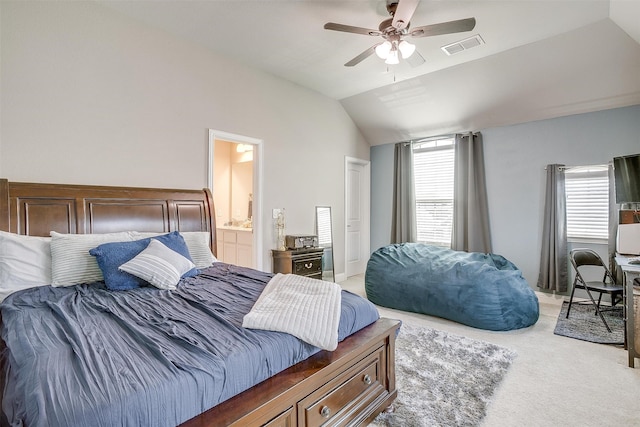 bedroom with lofted ceiling, ensuite bath, and multiple windows