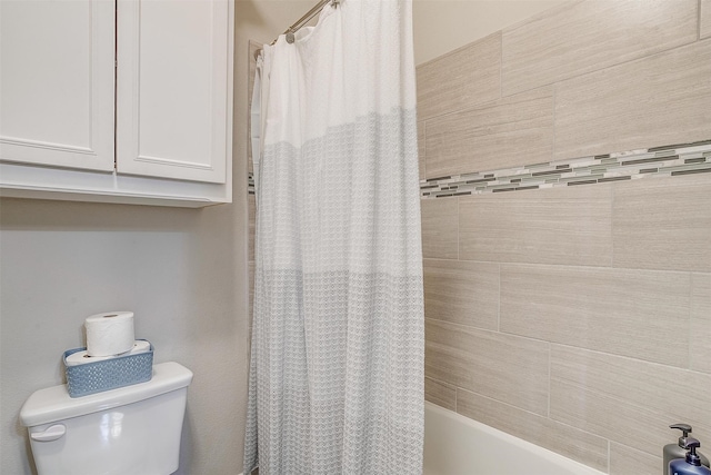 bathroom featuring shower / tub combo with curtain and toilet