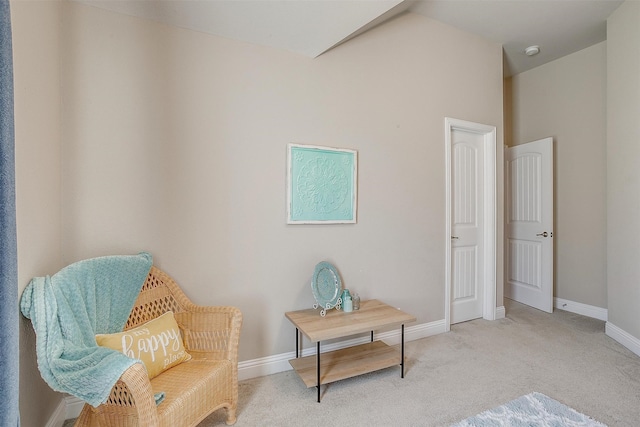 sitting room featuring lofted ceiling and light carpet