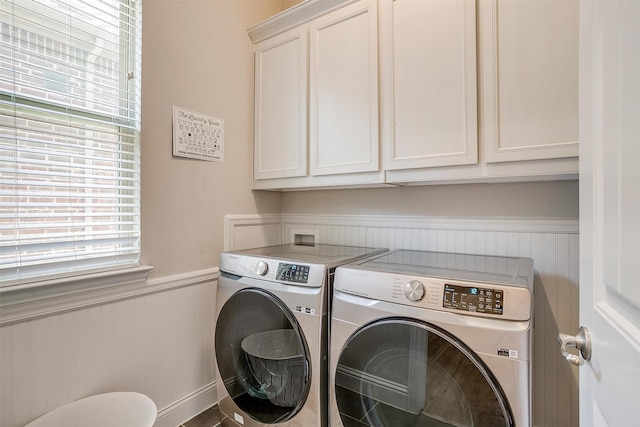 laundry area featuring washer and clothes dryer and cabinets