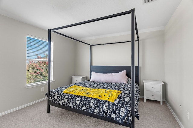 carpeted bedroom with ensuite bath and ceiling fan