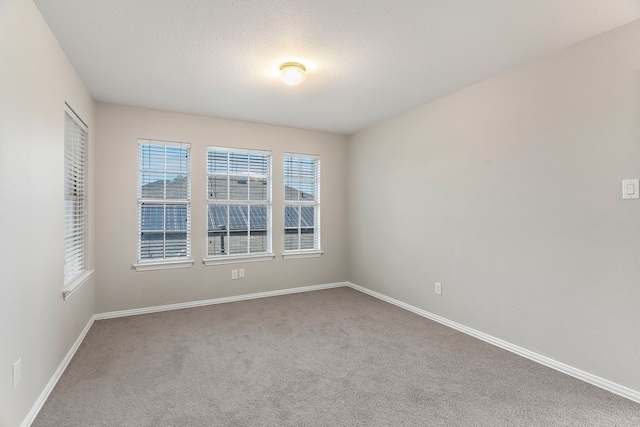 carpeted spare room featuring a textured ceiling