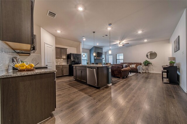 kitchen with stainless steel dishwasher, dark brown cabinets, decorative light fixtures, a kitchen island with sink, and dark wood-type flooring