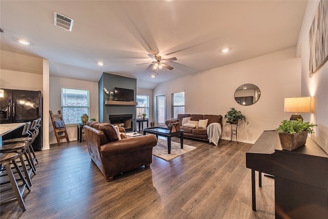 living room featuring ceiling fan and dark hardwood / wood-style floors