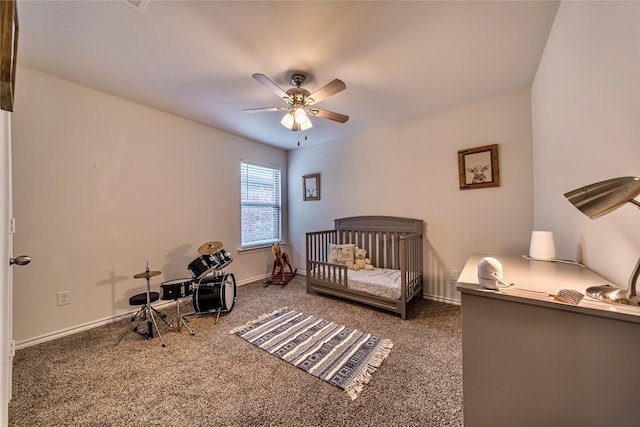 bedroom featuring ceiling fan, a nursery area, and carpet floors