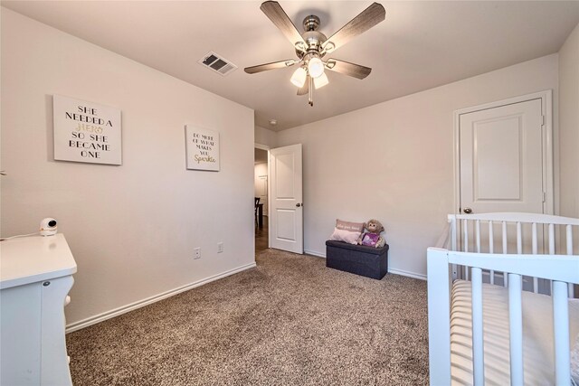 bedroom with carpet, ceiling fan, and a nursery area