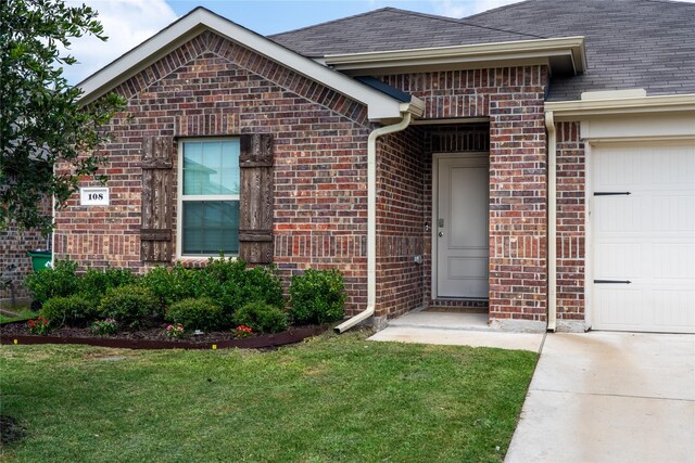 view of exterior entry with a lawn