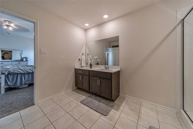 bathroom with tile patterned flooring, a shower with door, and vanity