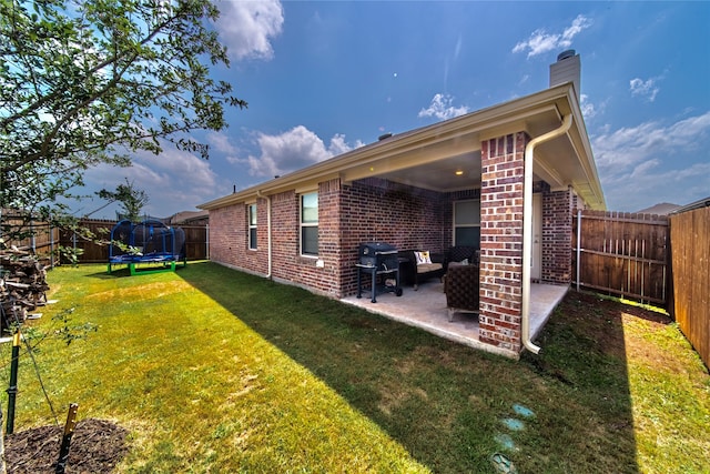 view of yard featuring a trampoline and a patio area