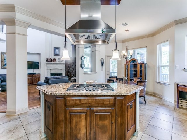 kitchen featuring a kitchen island, exhaust hood, decorative light fixtures, and stainless steel gas stovetop