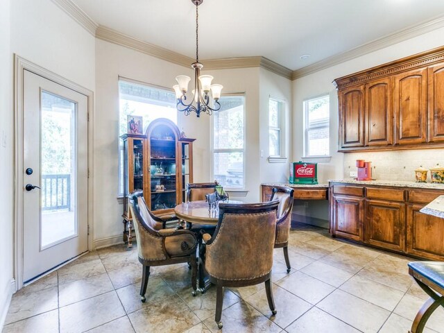 dining area featuring plenty of natural light, ornamental molding, and a notable chandelier