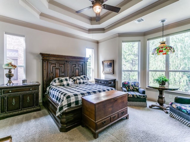 carpeted bedroom featuring a raised ceiling, ceiling fan, and ornamental molding