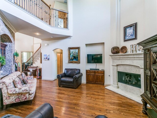 living room with a towering ceiling and dark wood-type flooring