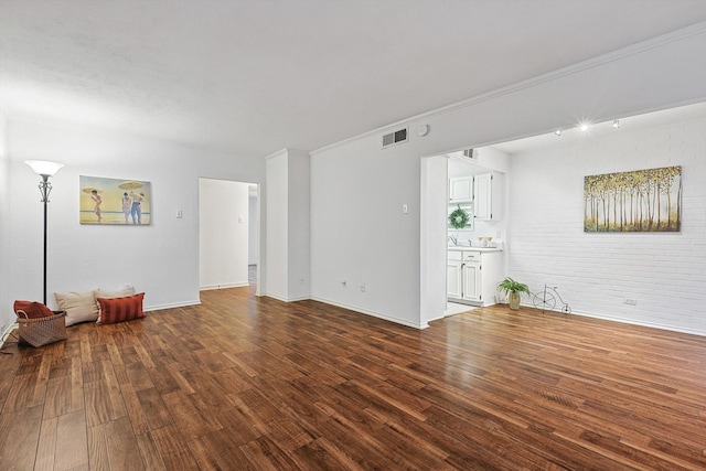 unfurnished living room featuring wood-type flooring and crown molding