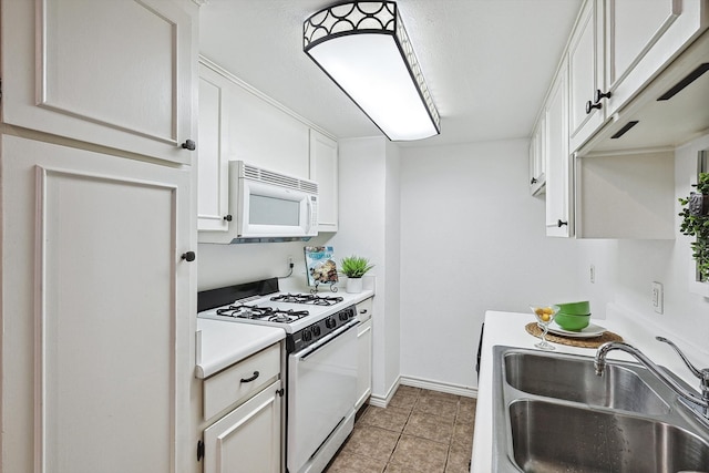 kitchen with sink, white cabinets, white appliances, and light tile patterned floors