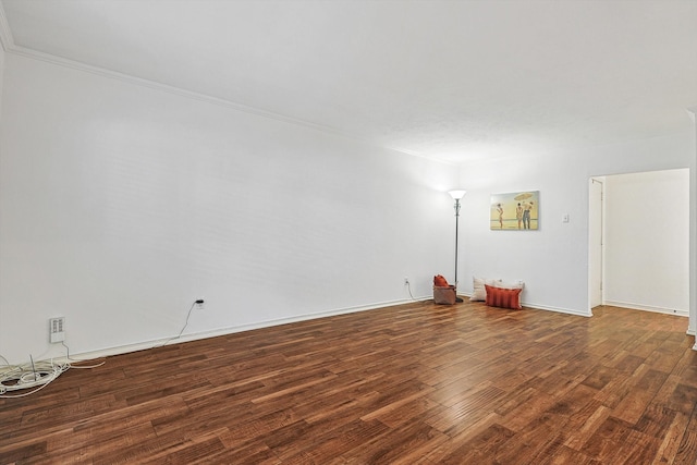 empty room featuring dark hardwood / wood-style flooring and crown molding