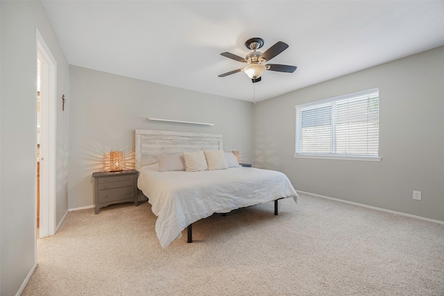 bedroom with ceiling fan and light colored carpet