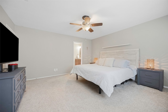 bedroom with ceiling fan, connected bathroom, and light carpet