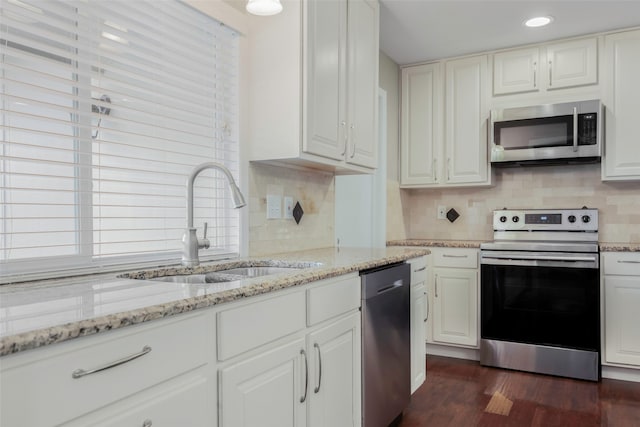 kitchen with dark hardwood / wood-style flooring, stainless steel appliances, white cabinets, and sink