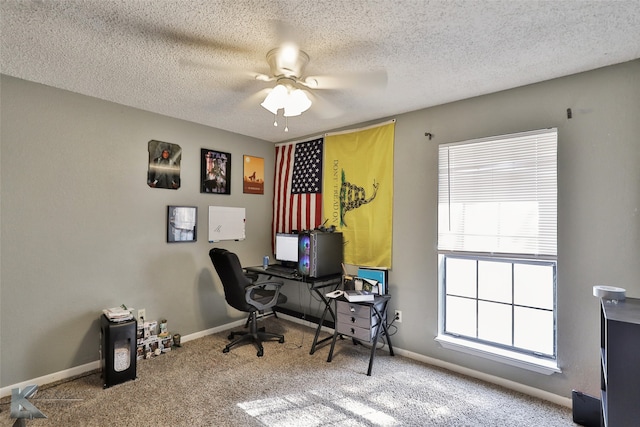 carpeted office space featuring ceiling fan and a textured ceiling