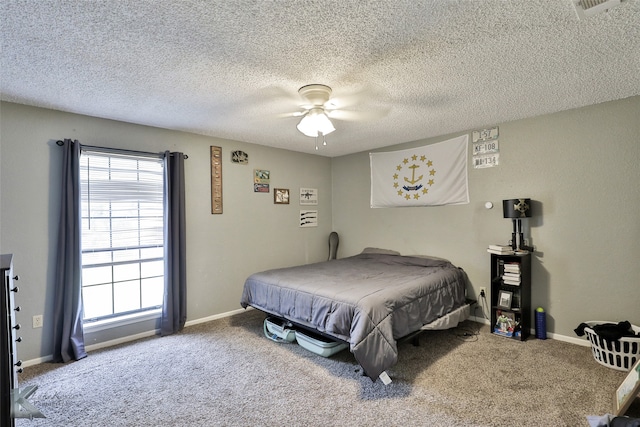 bedroom featuring ceiling fan, carpet floors, and a textured ceiling