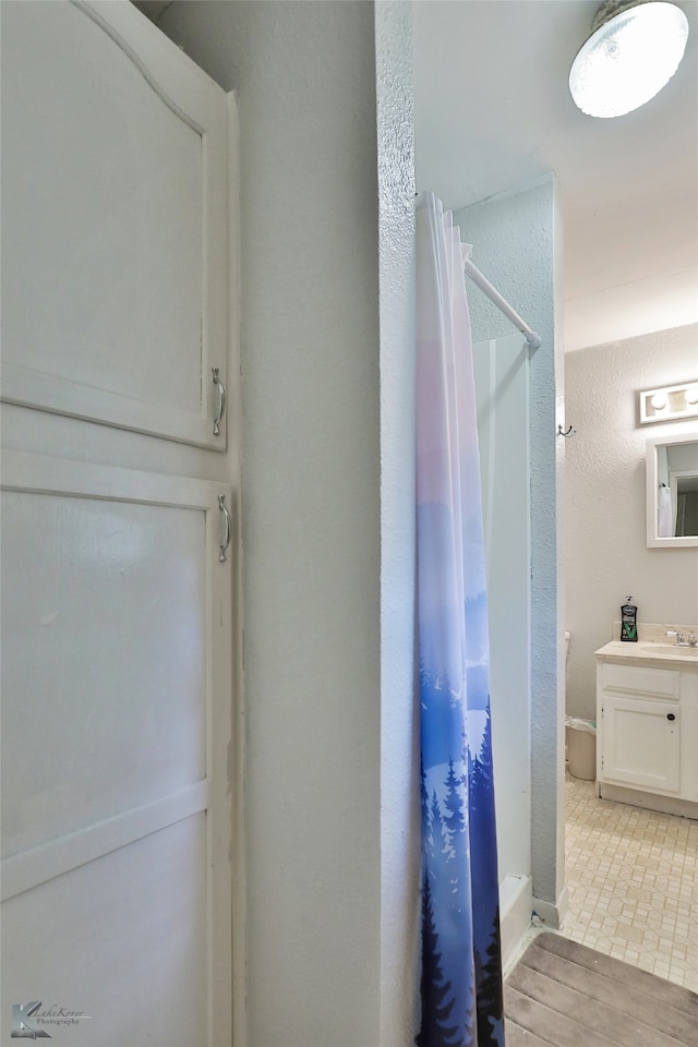 bathroom featuring walk in shower, wood-type flooring, and vanity