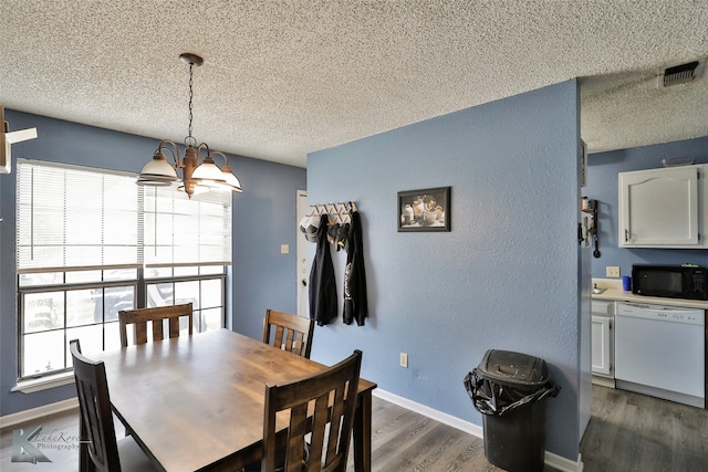 dining space featuring a notable chandelier, dark hardwood / wood-style flooring, and a textured ceiling