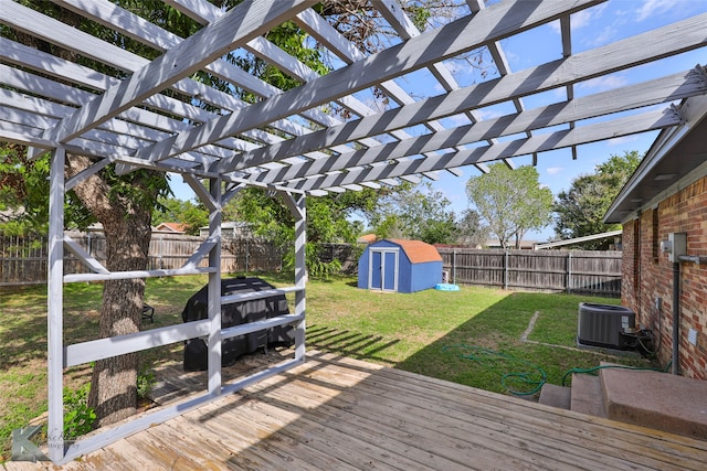 deck featuring cooling unit, a pergola, a lawn, and a storage unit