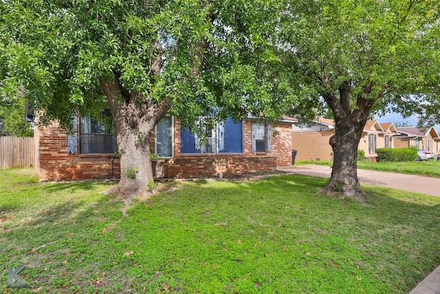 view of property hidden behind natural elements with a front yard