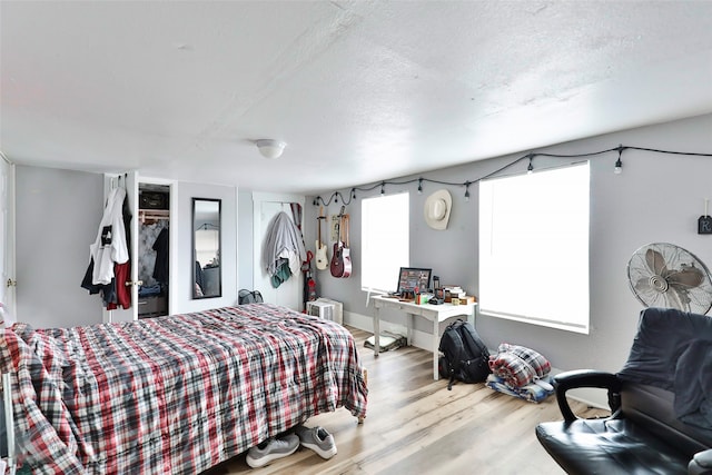 bedroom with a textured ceiling and light hardwood / wood-style flooring