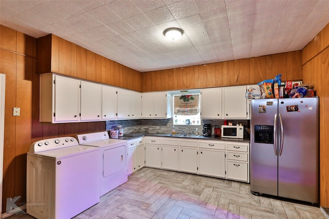 kitchen with light parquet flooring, washing machine and dryer, stainless steel fridge with ice dispenser, and white cabinetry