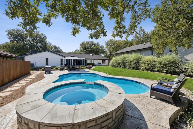 view of swimming pool with a yard, a sunroom, an in ground hot tub, and a patio area