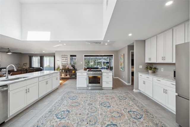 kitchen featuring white cabinets, stainless steel appliances, a wealth of natural light, and sink