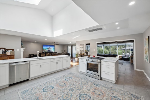 kitchen featuring a center island, sink, ceiling fan, white cabinetry, and stainless steel appliances