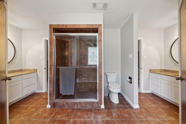 bathroom featuring tile patterned floors, vanity, toilet, and an enclosed shower