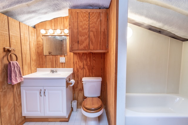 bathroom featuring wood walls, a bathing tub, vanity, tile patterned flooring, and toilet