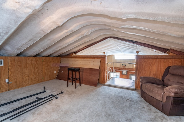 additional living space with light carpet, wooden walls, vaulted ceiling, and a textured ceiling