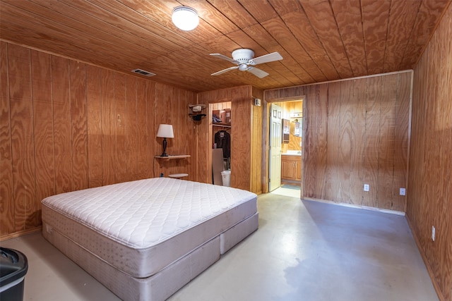 bedroom with wooden ceiling, ceiling fan, concrete flooring, ensuite bathroom, and wooden walls