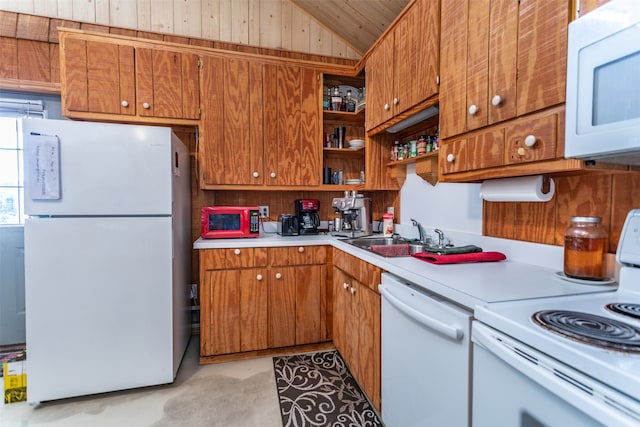 kitchen with white appliances, vaulted ceiling, and sink