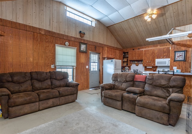 living room featuring high vaulted ceiling, wood walls, and ceiling fan