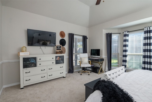 carpeted bedroom with vaulted ceiling, ceiling fan, and multiple windows