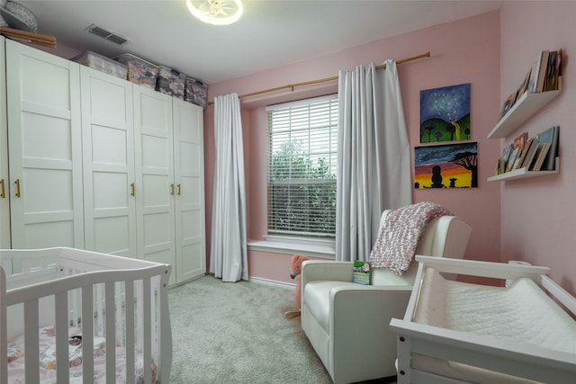 carpeted bedroom featuring a closet and a nursery area