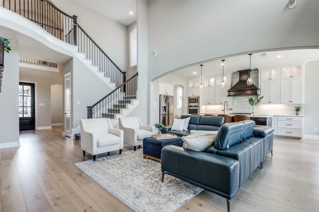 living room featuring light hardwood / wood-style flooring and a towering ceiling