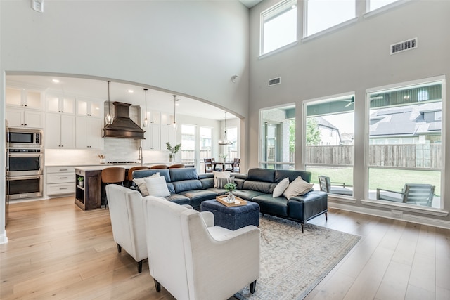 living room featuring a high ceiling and light hardwood / wood-style flooring