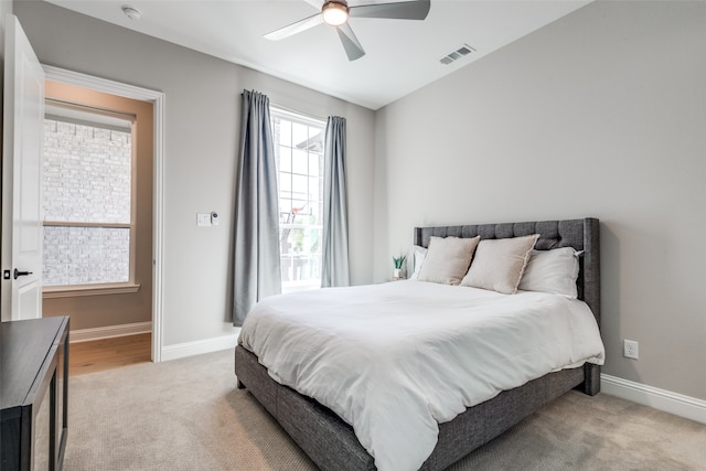 bedroom with ceiling fan and light colored carpet